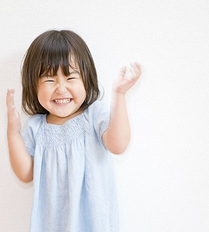 toddler with straight healthy teeth clapping with happiness about her easy visit with dr. doss