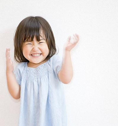 toddler with straight healthy teeth clapping with happiness about her easy visit with dr. doss