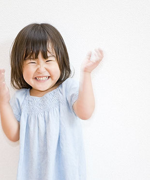 toddler with straight healthy teeth clapping with happiness about her easy visit with dr. doss