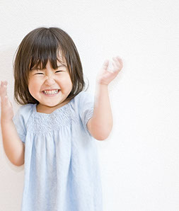 toddler with straight healthy teeth clapping with happiness about her easy visit with dr. doss